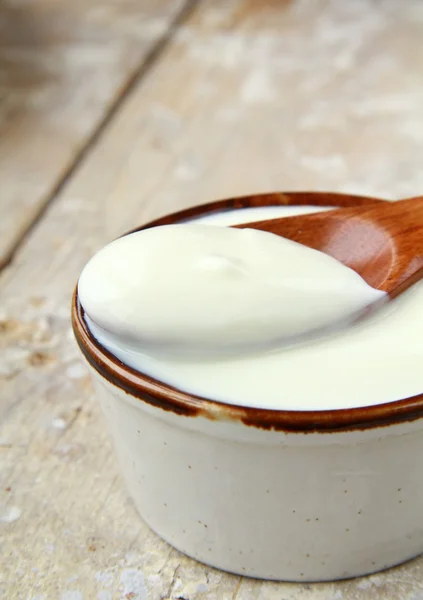 Fresh natural yoghurt in a ceramic cup on wooden table — Stock Photo, Image