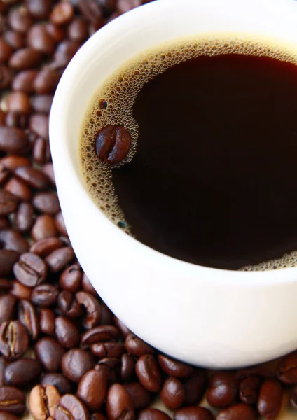 Tazza di caffè nero e chicchi di caffè — Foto Stock