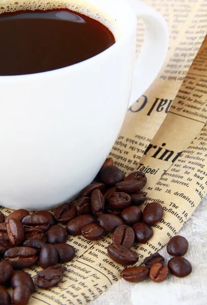 Xícara de café preto e grãos de café — Fotografia de Stock