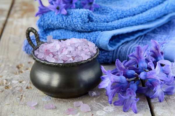 Spa still life. Bagno lilla sale, asciugamani e fiori — Foto Stock