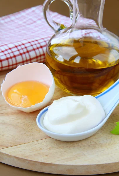 Majonéza s vajíčkem a olivový olej na dřevěné desce — Stock fotografie