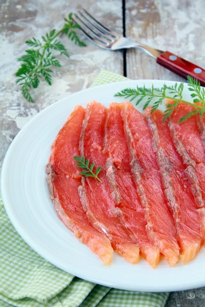 Pesce salato rosso di salmone tagliato a fette su un piatto — Foto Stock