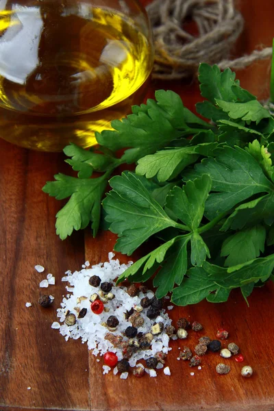 Salt, pepper, olive oil, parsley, on a wooden board — Stock Photo, Image