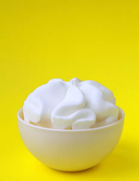 在黄色背景上的白色杯冰淇淋 — 图库照片