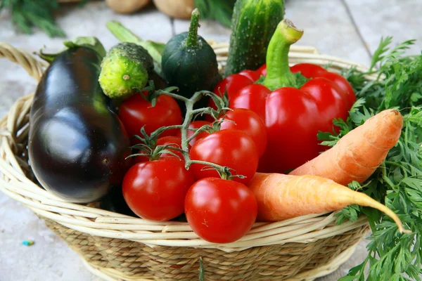 Různé čerstvá zelenina v proutěném koši na stůl — Stock fotografie