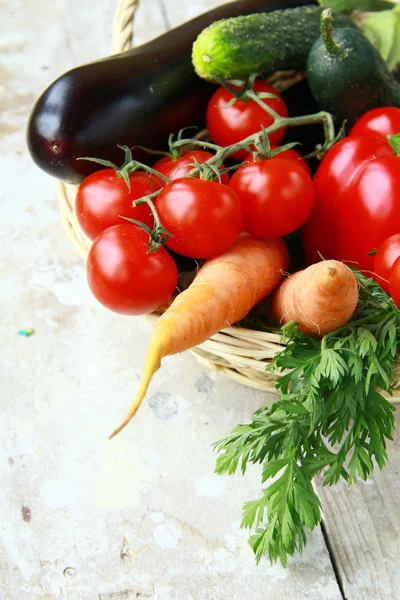 Verschillende verse groenten in een rieten mand op tafel — Stockfoto