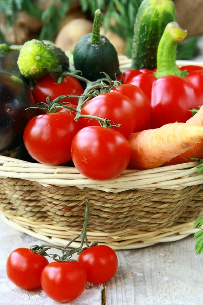 Verschiedenes frisches Gemüse in einem Weidenkorb auf dem Tisch — Stockfoto