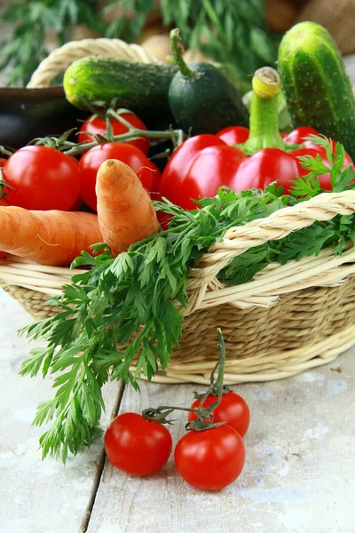 Verschiedenes frisches Gemüse in einem Weidenkorb auf dem Tisch — Stockfoto