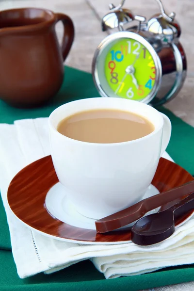 Tè con latte in una tazza bianca con un orologio sullo sfondo — Foto Stock