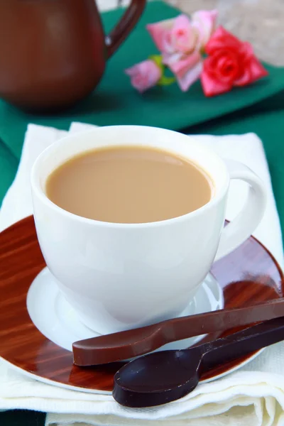 Tea with milk in a white cup on a green tablecloth — Stock Photo, Image
