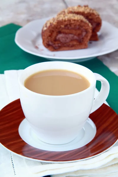 Tea with milk in a white cup on a green tablecloth — Stock Photo, Image