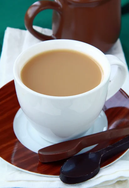 Τσάι με γάλα σε ένα λευκό φλιτζάνι με κουτάλια Επιδόρπιο σοκολάτας — Φωτογραφία Αρχείου