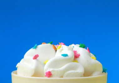Ice cream in a white cup with multi-colored candies clipart