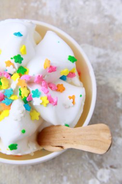 çok renkli şekerler ile beyaz bir fincan dondurma