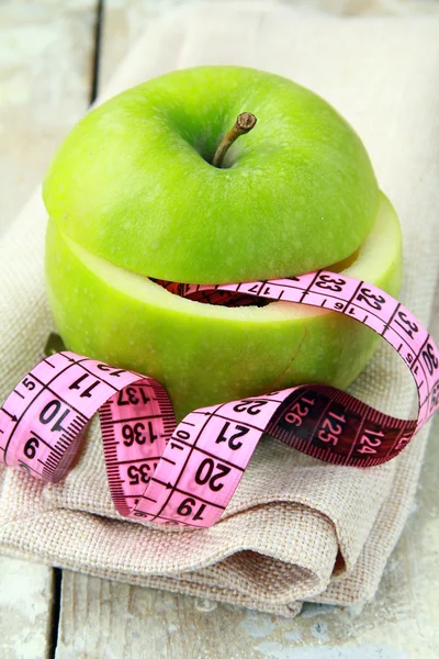 Manzana y una cinta métrica, concepto de dieta —  Fotos de Stock