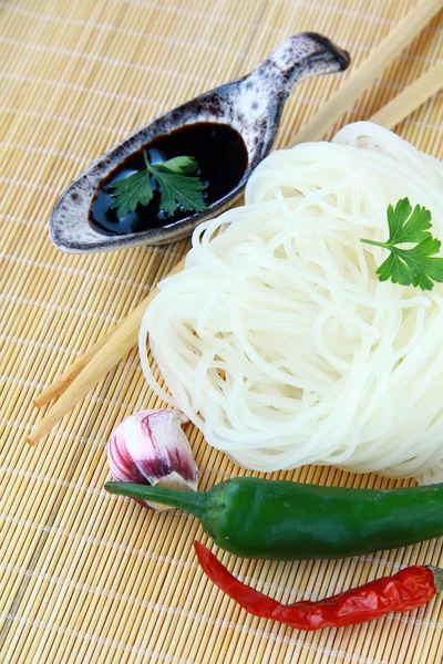 Nouilles asiatiques en verre, piment et sauce soja sur tapis de bambou — Photo