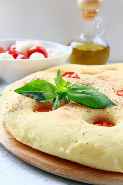 stock image Italian Focaccia bread with tomatoes and basil on a cutting board