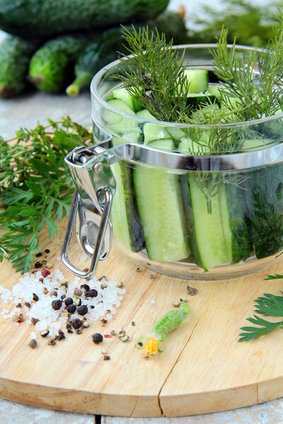 Cucumbers in the jar with dill salt and pepper on the table