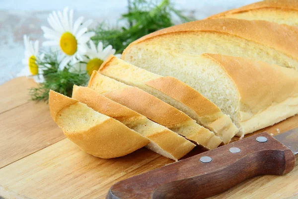 Taze beyaz somun ekmek bıçağı ve papatyalar, rustik tarzı ile — Stok fotoğraf