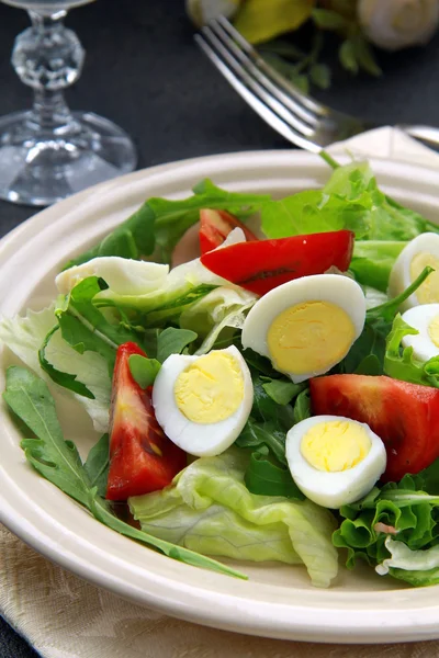 Salad with quail eggs and arugula on beige plate black background — Stock Photo, Image