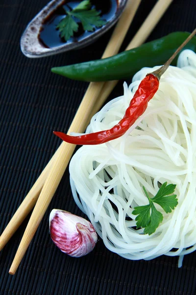 Asiatiska glasnudlar, chili peppar och soja på bambu matta — Stockfoto