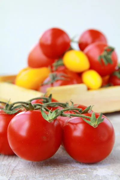 Several varieties of tomatoes in a box on the table — Stock Photo, Image