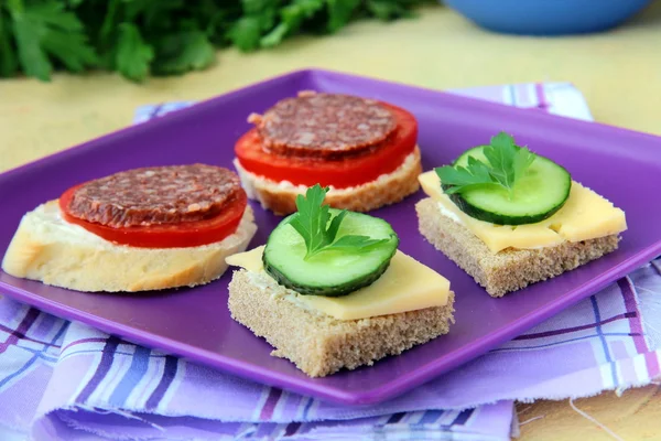 KANAPE mackor med ost och salami på lila plattan — Stockfoto