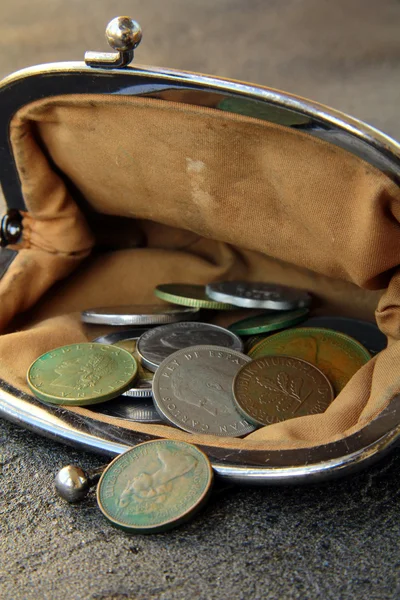Monedas antiguas en el bolso vintage abierto sobre un fondo negro —  Fotos de Stock