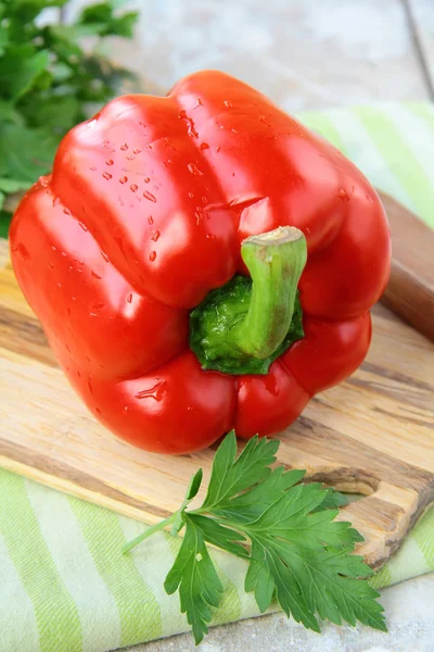 Large red bell paprika peppers on a cutting board — Stock Photo, Image