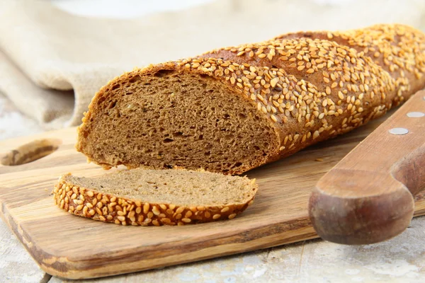 Багет ржаной черный хлеб на деревянной доске — стоковое фото
