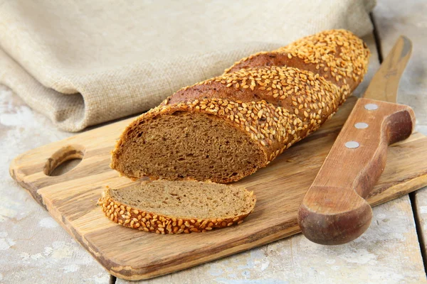 Багет ржаной черный хлеб на деревянной доске — стоковое фото