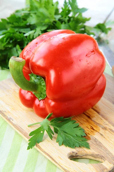 Stor rød klokke paprika peberfrugter på et skærebræt - Stock-foto
