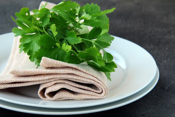 Las planchas con la servilleta de lino y la rama del perejil - el menú orgánico —  Fotos de Stock