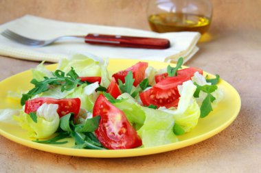 taze salata domates ve roka, arka planda zeytin yağı ile