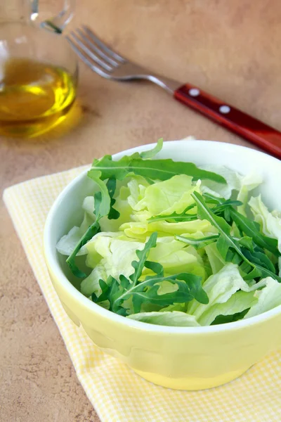 Salad mix iceberg and arugula, olive oil in the background — Stock Photo, Image