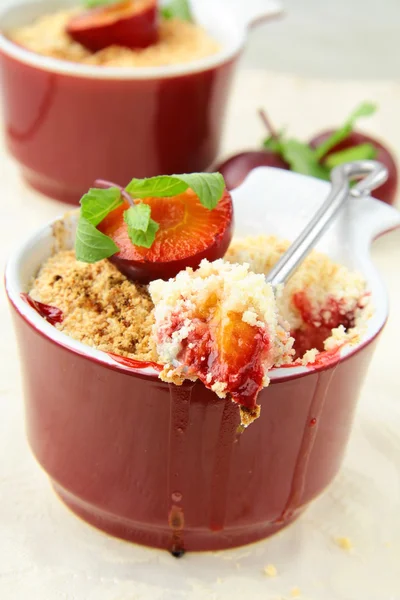 Smula ner plommon dessert med mynta i en kopp — Stockfoto