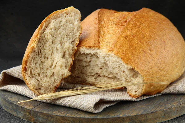 Буханка белого хлеба на деревянной кухонной доске — стоковое фото