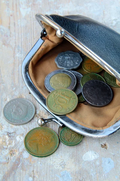 Monedas antiguas en el bolso vintage abierto sobre un fondo de madera — Foto de Stock