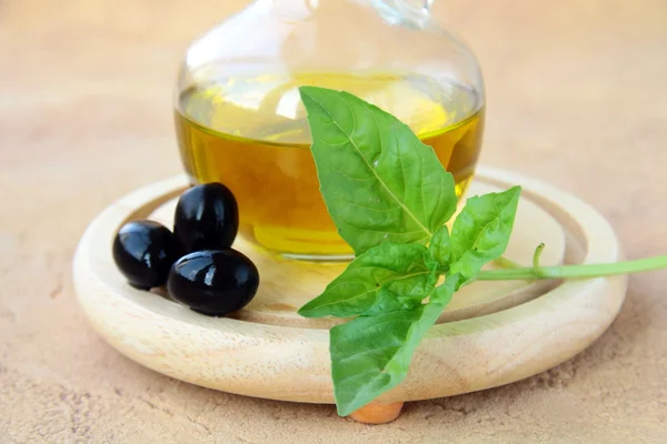 Fles olijfolie en een takje basilicum — Stockfoto