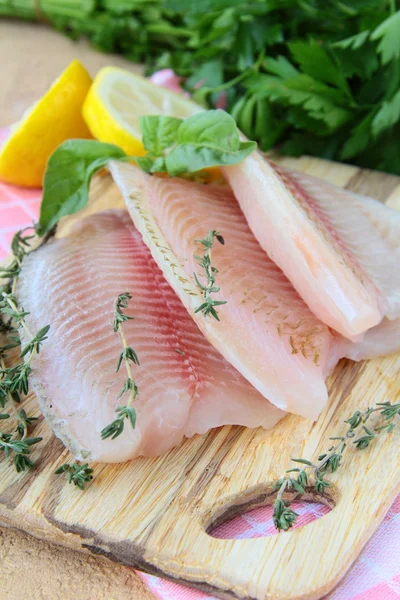 Otlar ve baharatlar mutfak tahtası ile taze çiğ balık fileto — Stok fotoğraf
