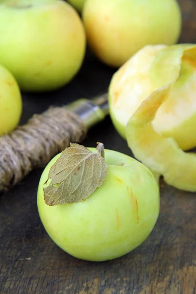 Зеленые органические яблоки из кожуры на деревянной доске — стоковое фото