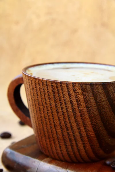 Kaffee-Cappuccino in einer stilvollen Holztasse mit Kaffeebohnen — Stockfoto