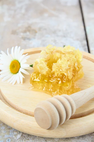 Favo de mel em um suporte de madeira na mesa — Fotografia de Stock