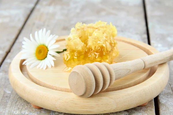 Favo de mel em um suporte de madeira na mesa — Fotografia de Stock