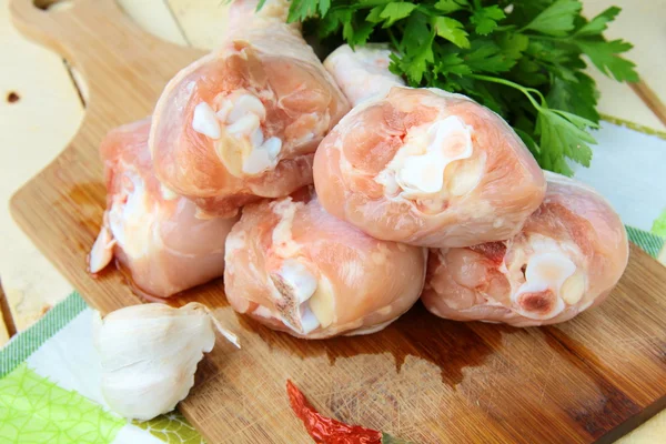 Pernas de frango frescas cruas em uma placa de cozinha — Fotografia de Stock