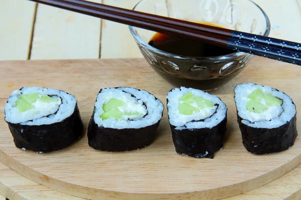 Rolos de sushi japonês com pepino com wasabi e pauzinhos — Fotografia de Stock