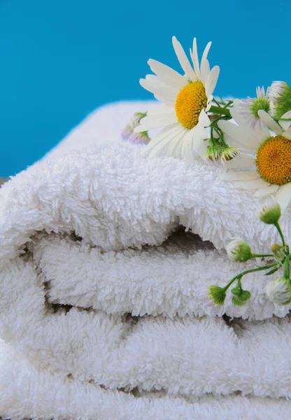 White towel with daisies on a wooden table — Stock Photo, Image