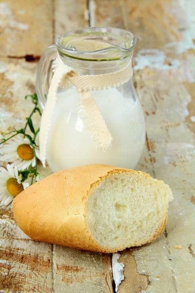 Jarra de leche y pan blanco sobre una mesa de madera naturaleza muerta rústica —  Fotos de Stock