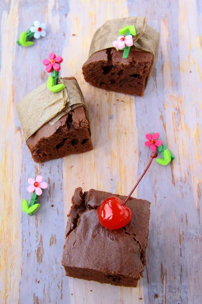 Brownie-Schokoladenkuchen mit Kirschen auf braunem Hintergrund — Stockfoto