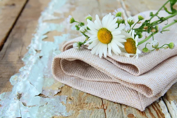 Bouquet di margherite sulla borsa di lino su una tavola di legno natura morta rustica — Foto Stock